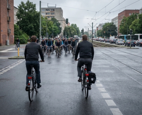 Radpendler auf breitem Radweg in Berlin, im Hintergrund dicht gedrängte Radfahrer an überfülltem Radwegabschnitt
