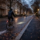 Radfahrer im Berliner Herbstdunkel mit schwachem Licht auf nasser, unbeleuchteter Straße